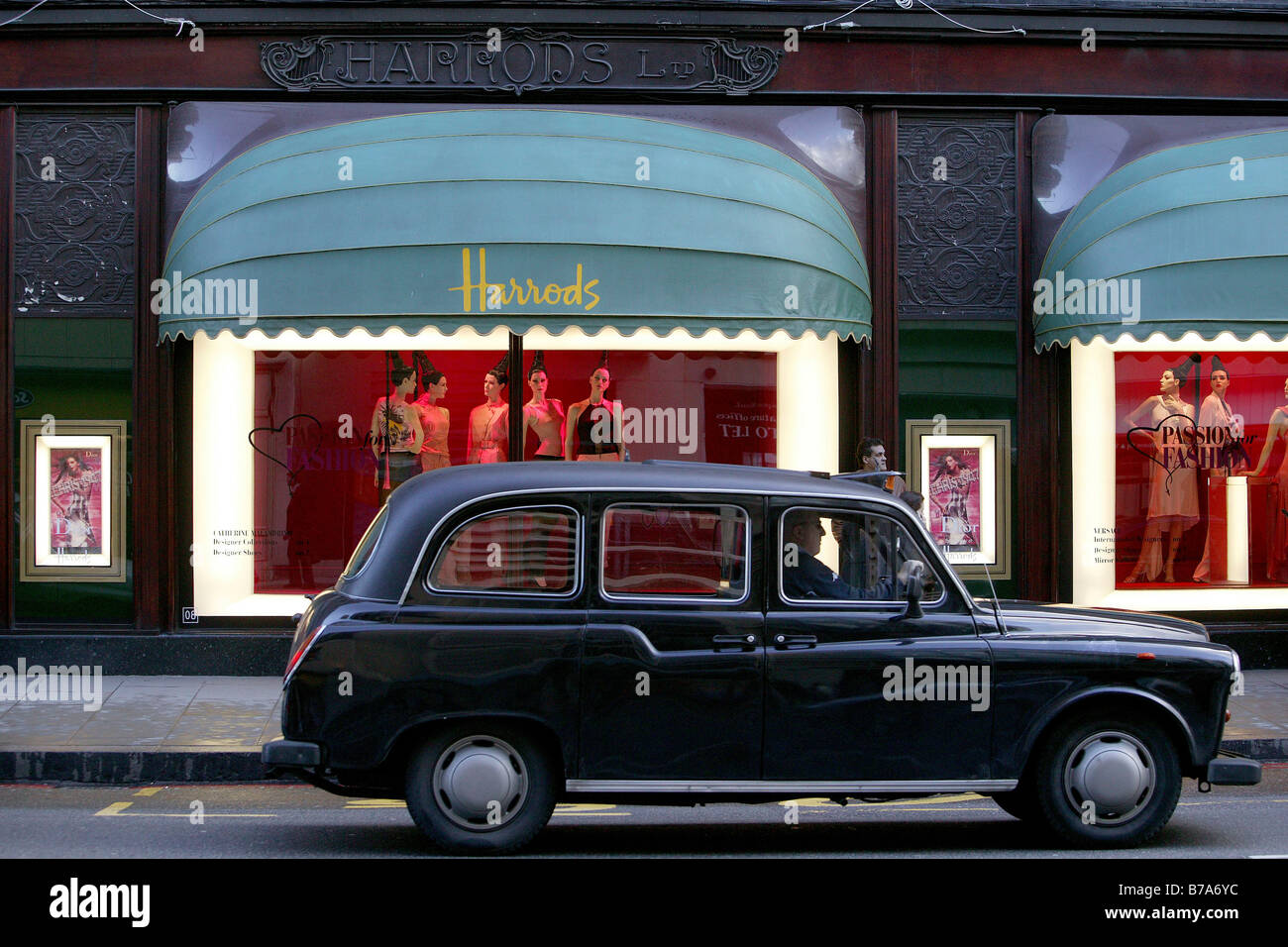 Taxi vor einem Schaufenster von Harrods Kaufhaus, London, England, Großbritannien, Europa Stockfoto