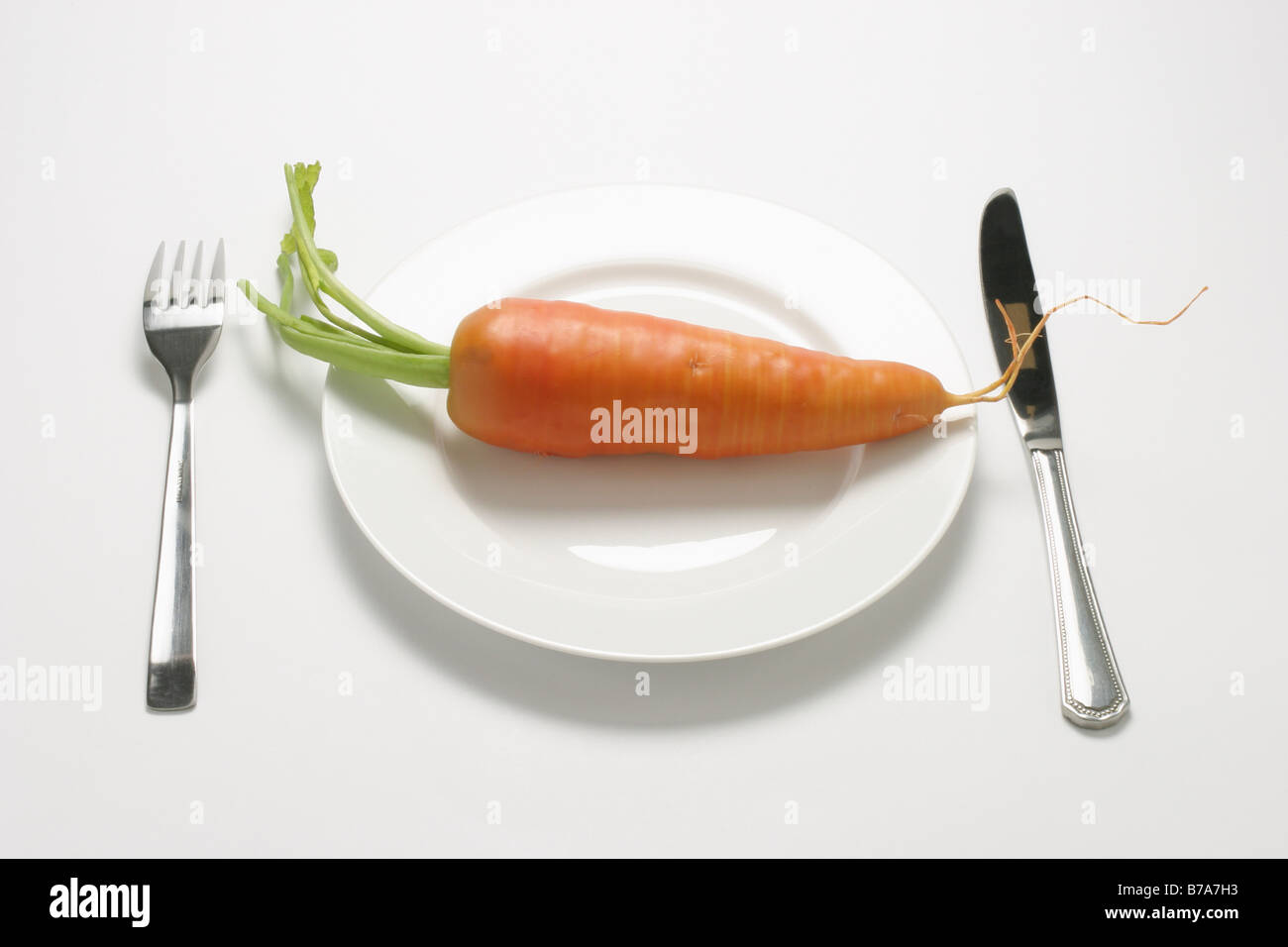 Frischen Karotten auf einem Teller mit Messer und Gabel Stockfoto