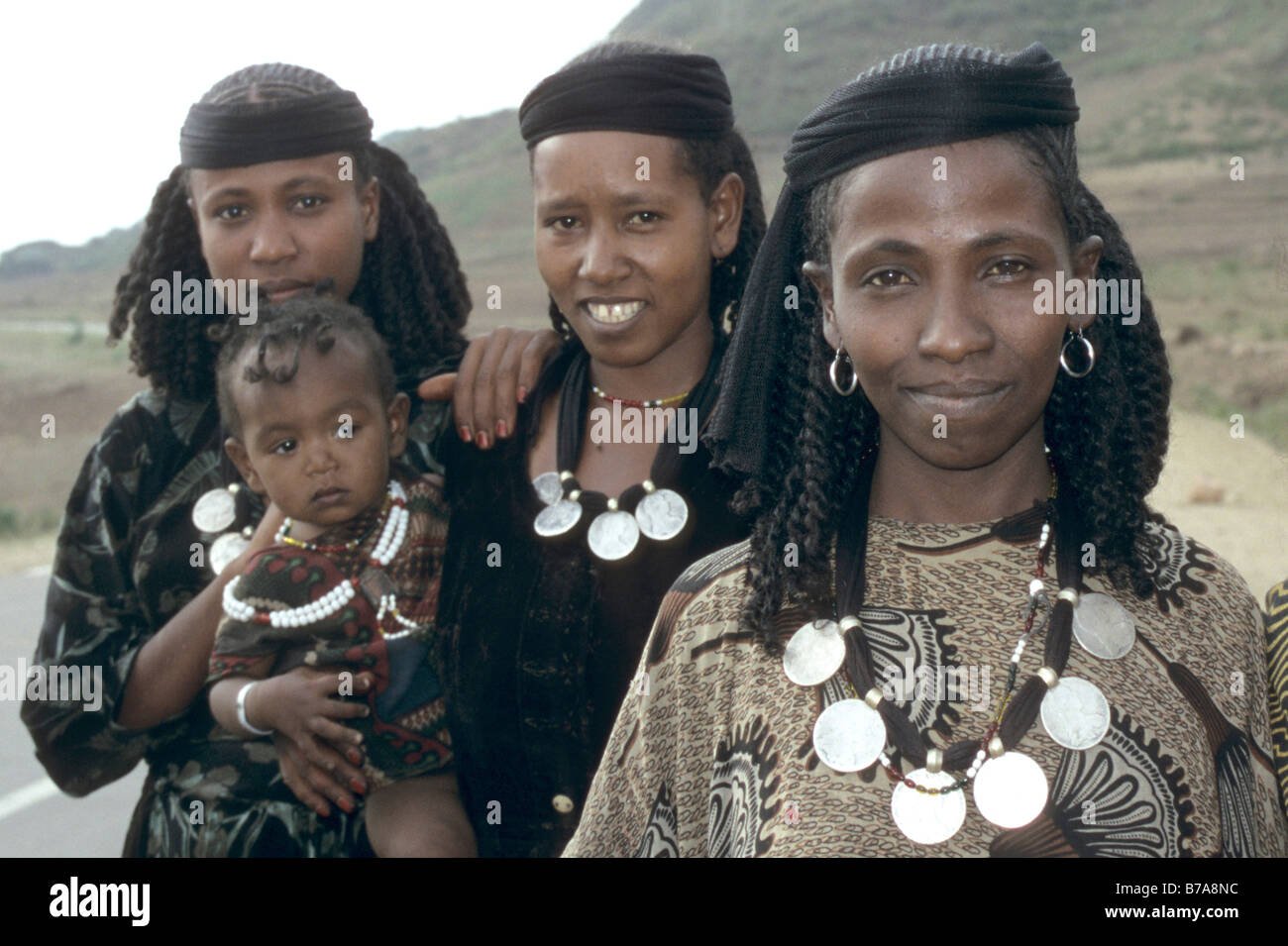 Gruppe von drei Oromo Frauen, einer von ihnen hält ein Kleinkind, jeder trägt eine Halskette von Silberscheiben. Stockfoto