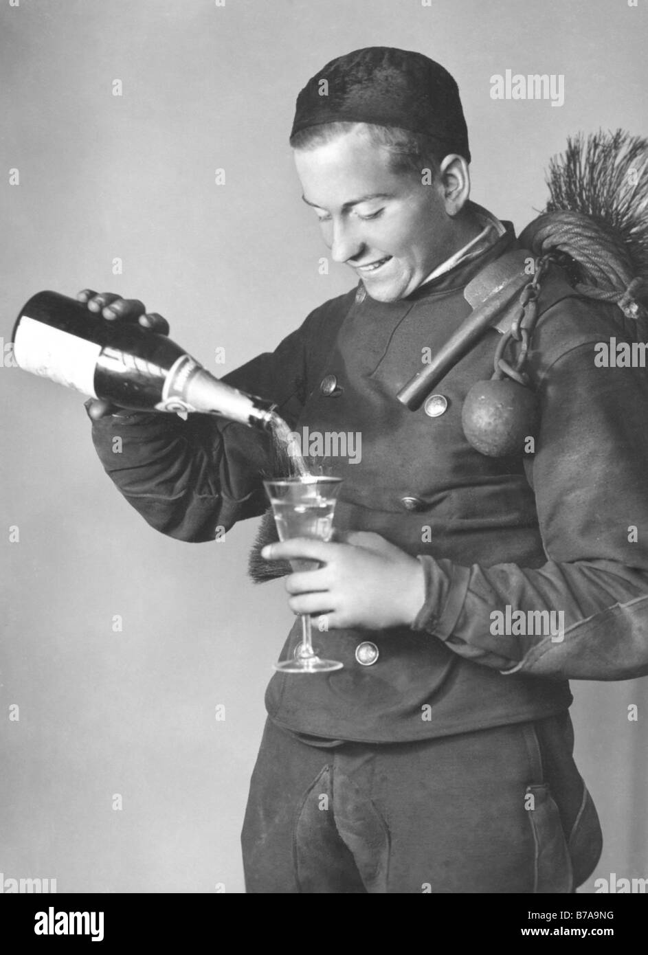Historisches Foto, Schornsteinfeger mit Champagner-Flasche, Glücksbringer, ca. 1920 Stockfoto