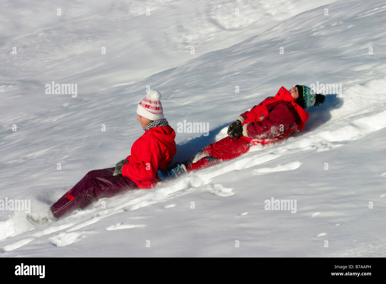 Zwei Mädchen, 9 und 12 Jahre alt, Reiten auf Schnee-Schieber, Dolomiten, Italien, Europa Stockfoto