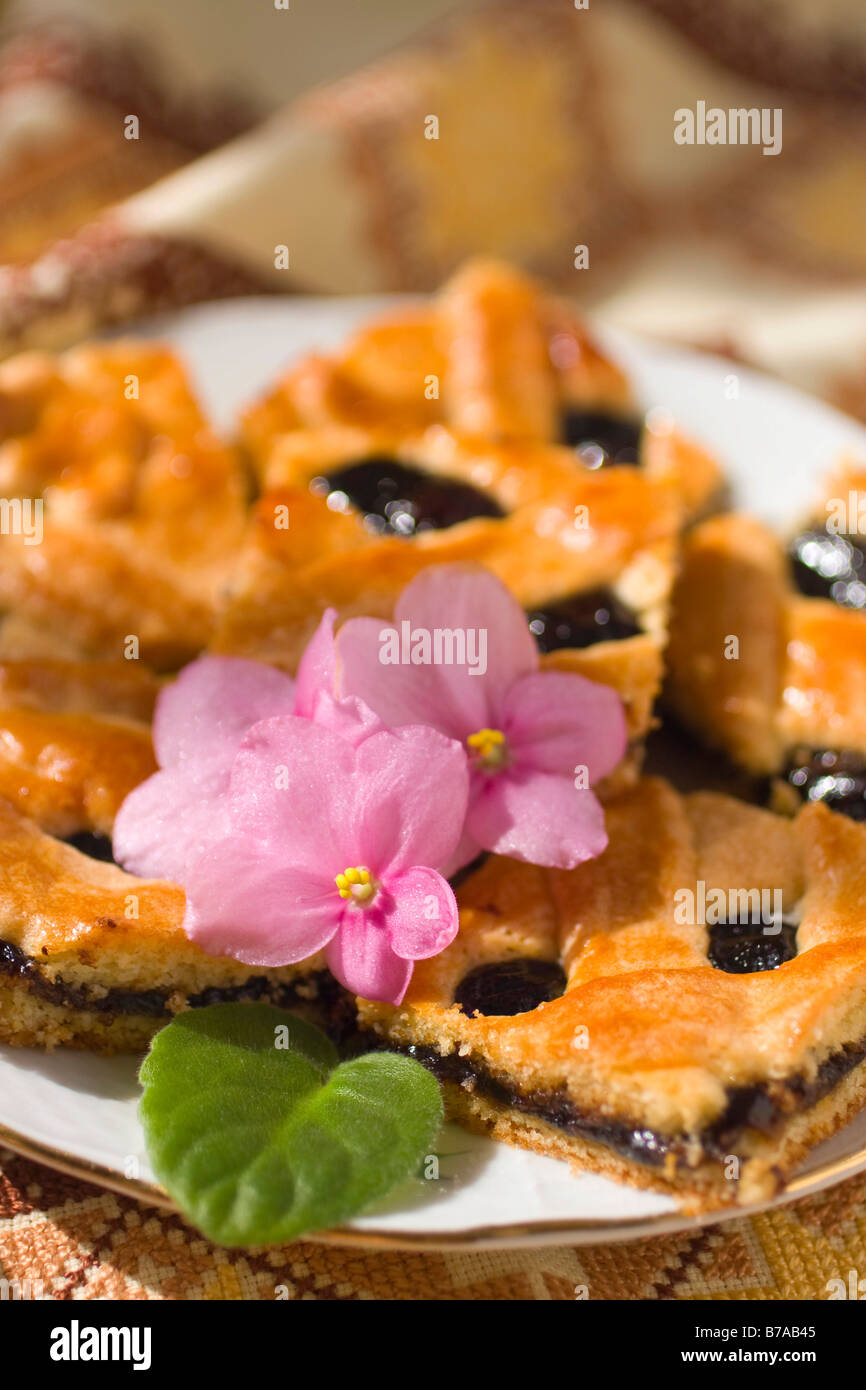 Pflaumenmus-Käsekuchen mit Blumen-Dekor Stockfoto