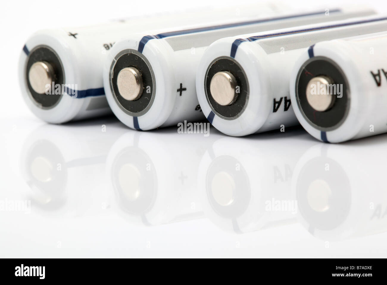 vier weiße alkaline-Batterien auf weißem Hintergrund mit Reflexion Stockfoto