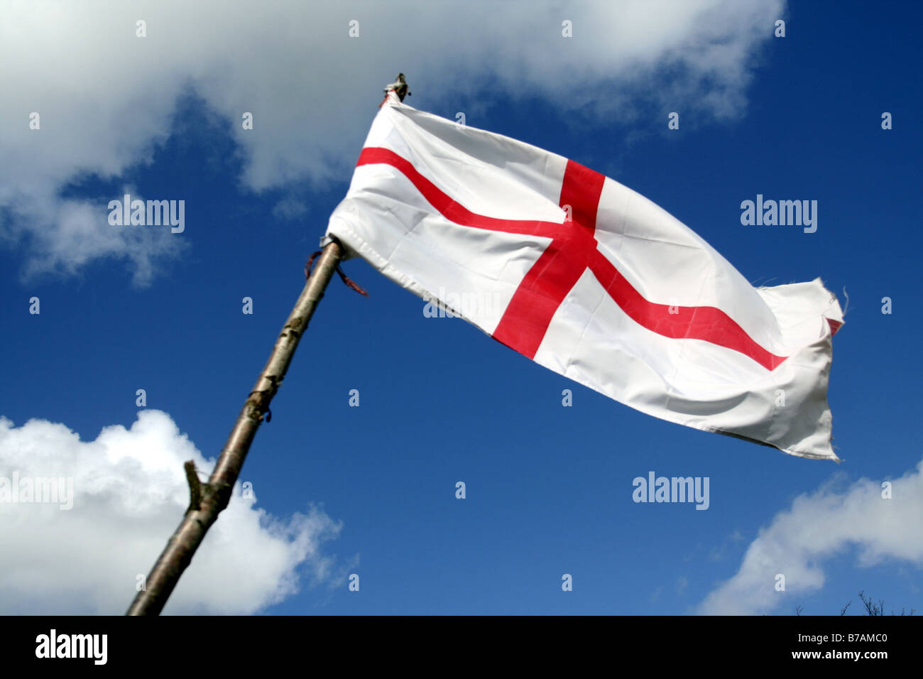 Englands St George Flagge am Holzstab mit blauem Himmelshintergrund Stockfoto