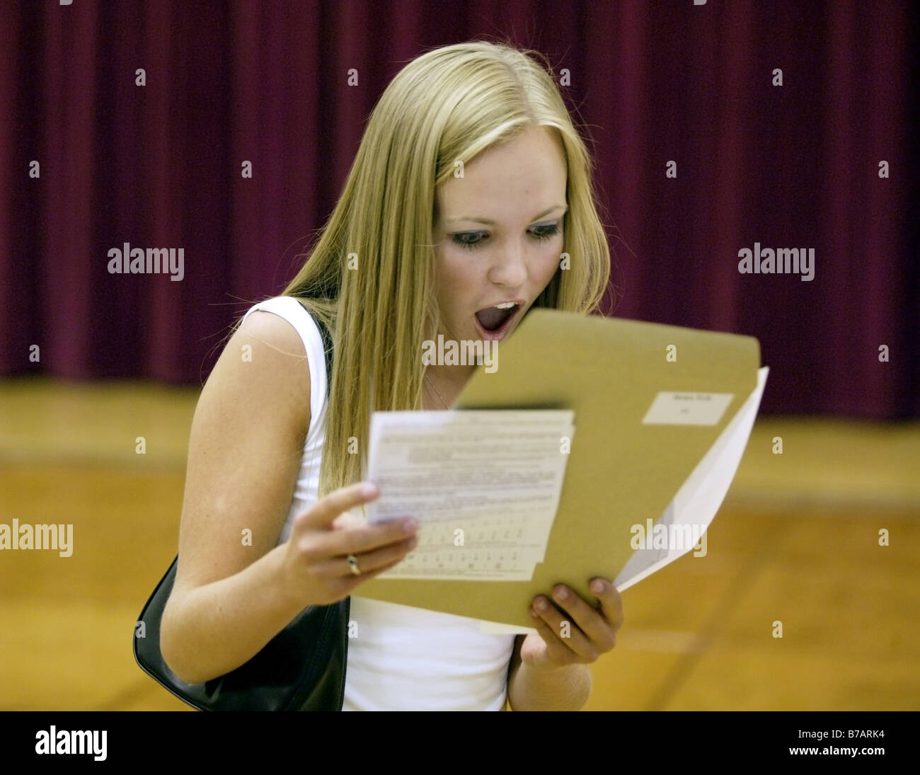 Eine Mädchen lesen ihre GCSE Resultate in der Schule in Shropshire kann ihre Freude nicht verbergen. Stockfoto