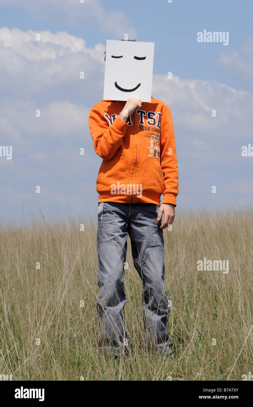 Junge im Feld Holding Smiley-Gesicht Stockfoto