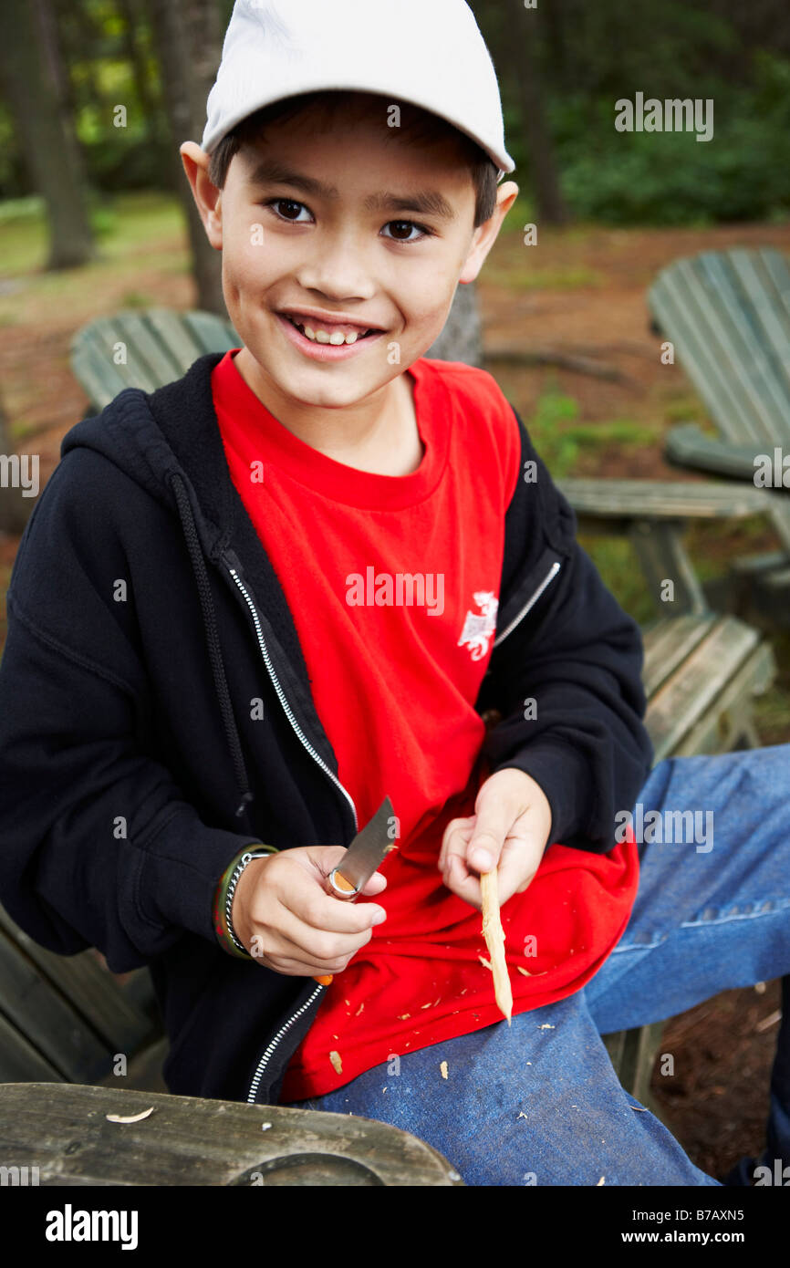 Junge schnitzen einen Stick mit seinem ersten Taschenmesser, Algonquin Park, Ontario, Kanada Stockfoto