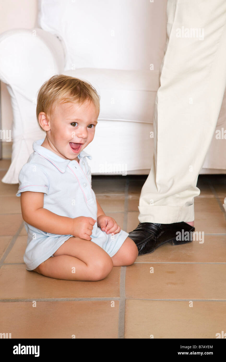 Kleiner Junge auf dem Boden sitzend Stockfoto