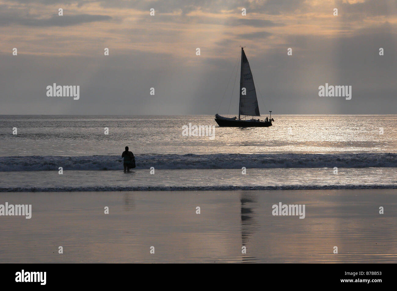 Surfer und Segelboot genießen Sie einen wunderschönen Sonnenuntergang am Venice Beach, Kalifornien, USA. Stockfoto