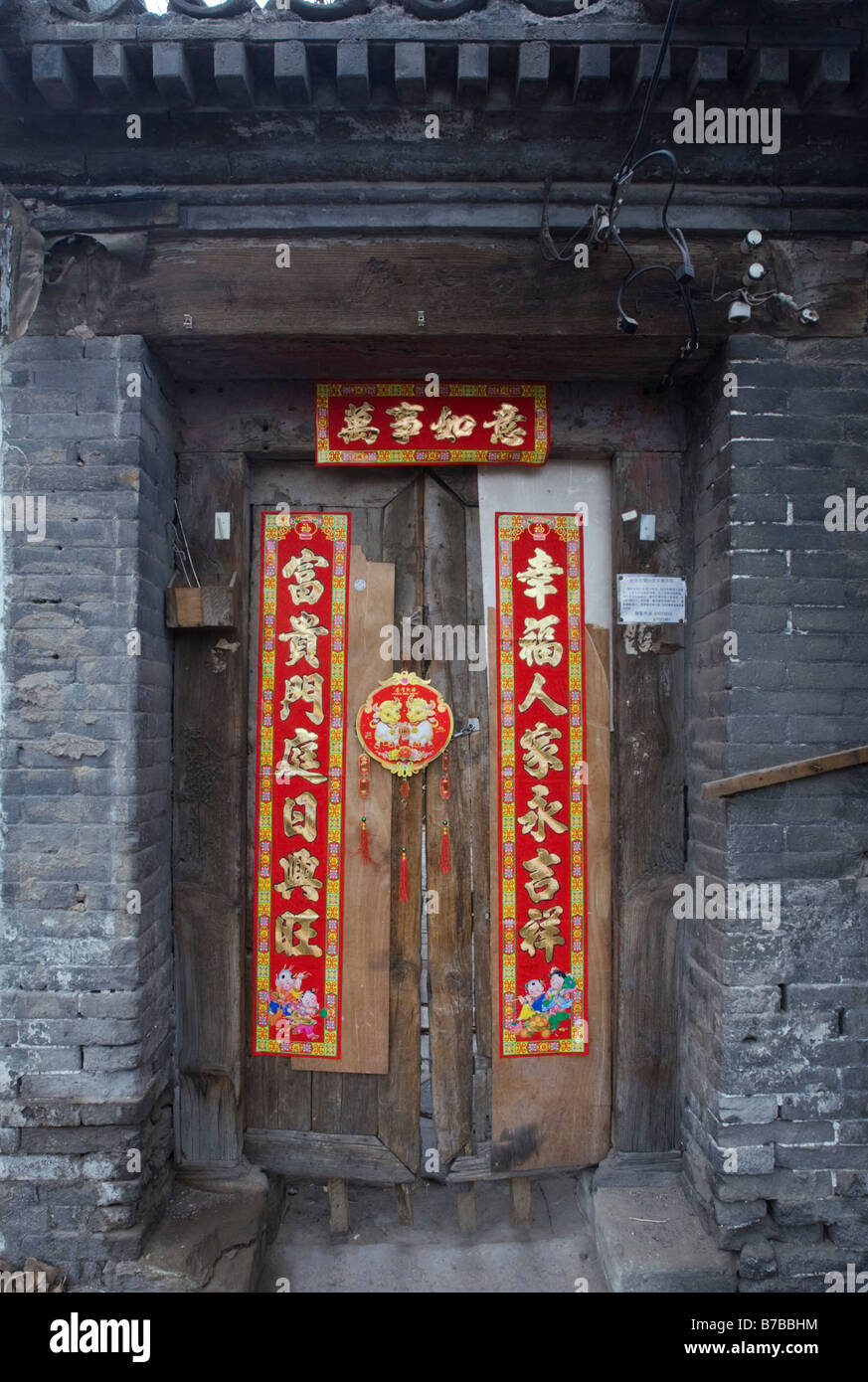 Traditionelle chinesische Neujahr Dekorationen auf einer alten Holztür in ein Haus in einem Beijing Hutong Januar 2009 Stockfoto