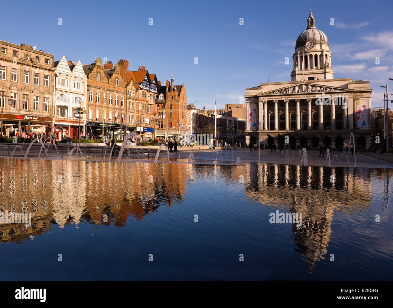 Das Rathaus von Nottingham und die Geschäfte am Old Market Place und die South Parade spiegeln sich im Wasser des Brunnens Stockfoto