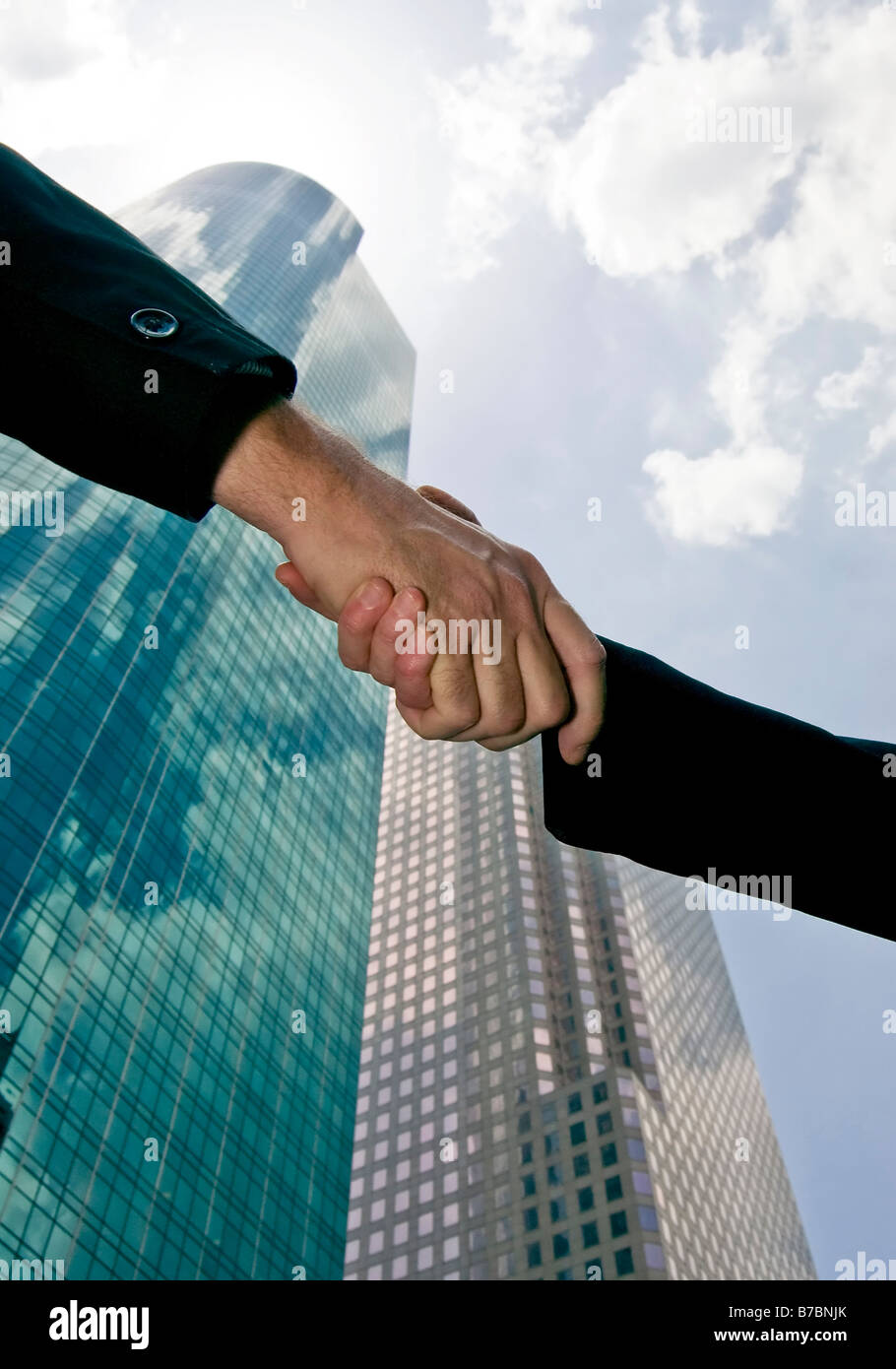 Ein Handschlag gegen einen Himmel mit schönen Longdrinkglas Türmen des Handels füllen den Hintergrund Stockfoto