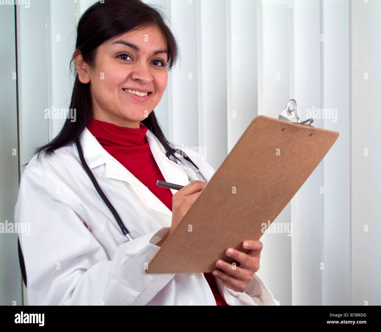 Ein junger Arzt mit einem Diagramm in der Hand mit großen Lächeln auf ihrem Gesicht Stockfoto