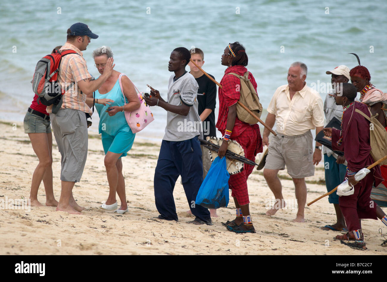Touristen belästigt durch einheimische Männer an einem Strand in Mombasa, Kenia. Sie versuchen, diese Schmuckstücke zu verkaufen Stockfoto