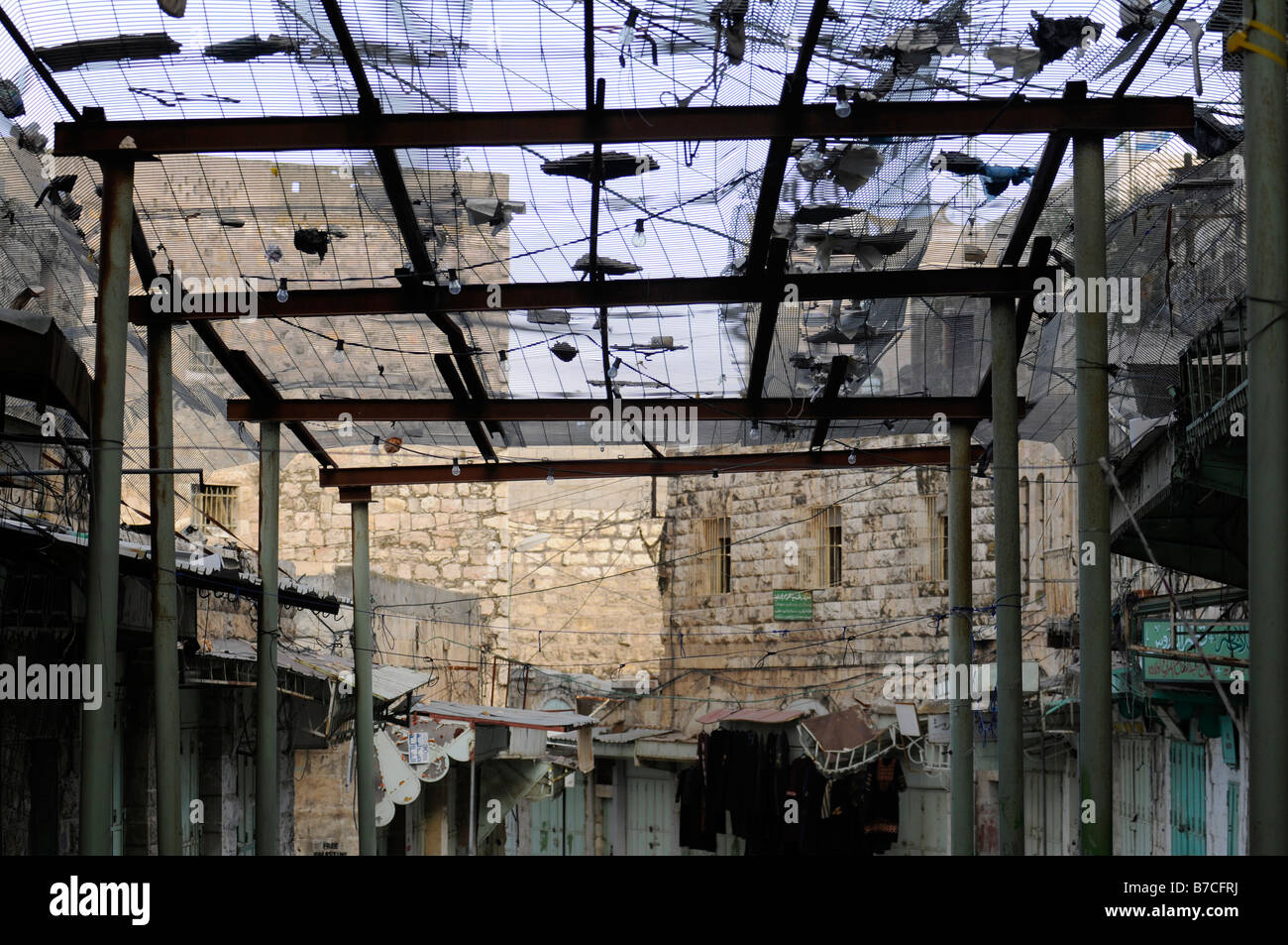 Straßenszene in Hebron unter israelischer Besatzung: ein Zaun zum arabischen Fußgänger vor Papierkörbe geworfen, von jüdischen Siedlern zu schützen Stockfoto