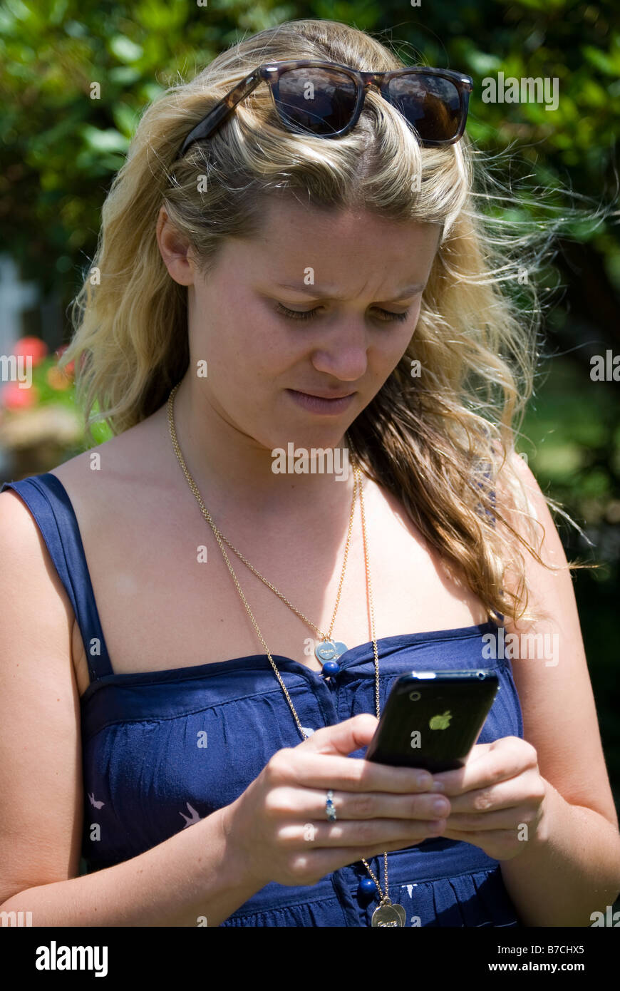 Junge Frau SMS auf Handy, Christchurch, Canterbury, Neuseeland Stockfoto