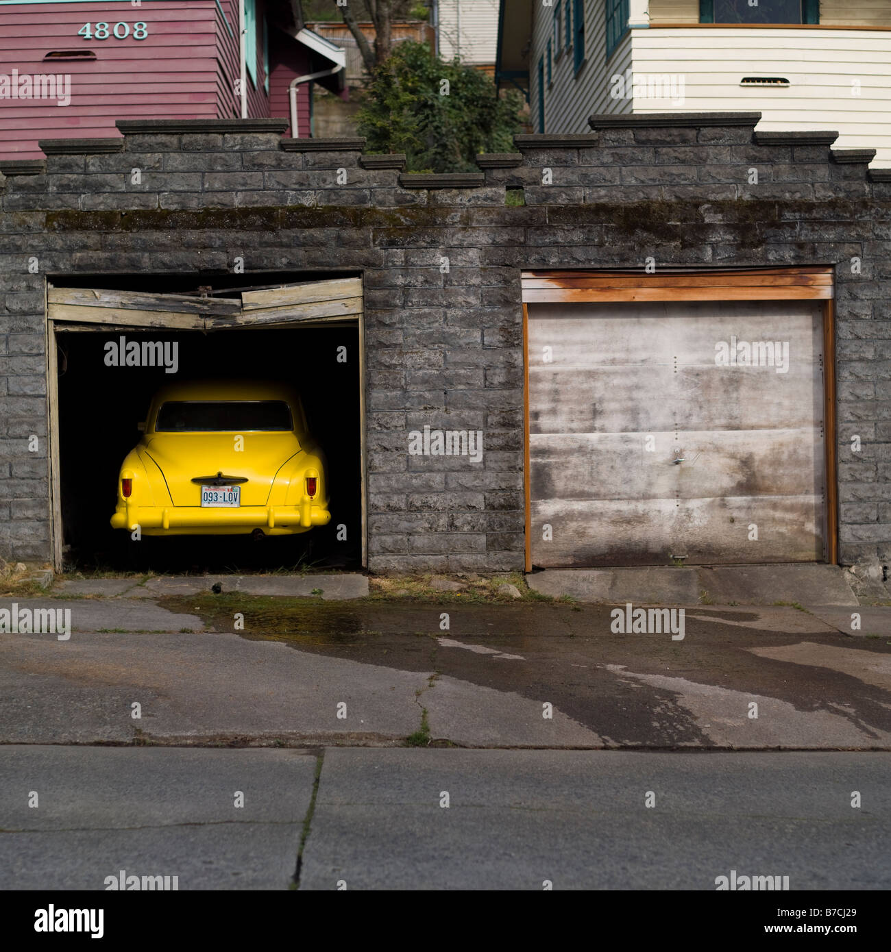 Ein altes gelbes Auto sitzt in einem ebenso alten Garage. Corbis Exklusive Stockfoto