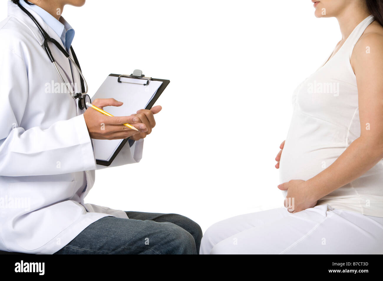 Schwangere junge Frau berühren Bauch vor einem Arzt hält einen Stift und Zwischenablage Stockfoto