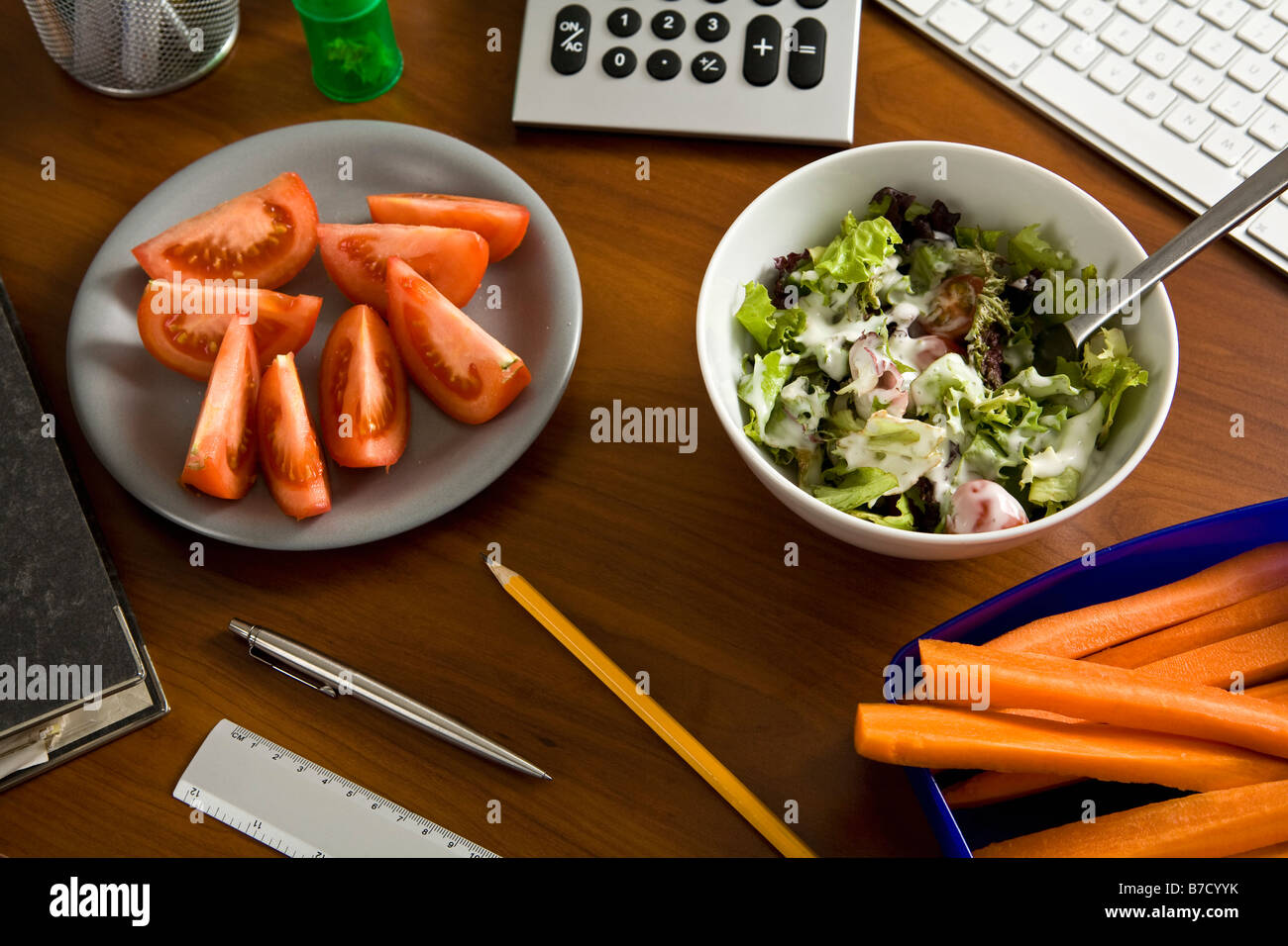 Ein Schreibtisch mit Büromaterial und gesunde Ernährung Stockfoto