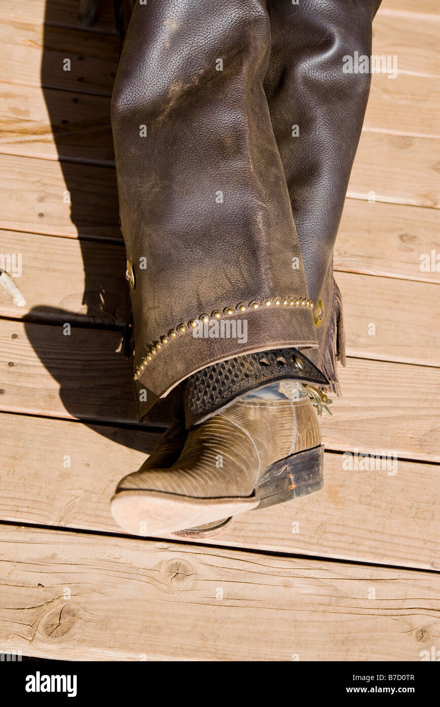 Lederstiefel und Chaps ein Cowboy auf einem hölzernen Fußboden liegend Stockfoto