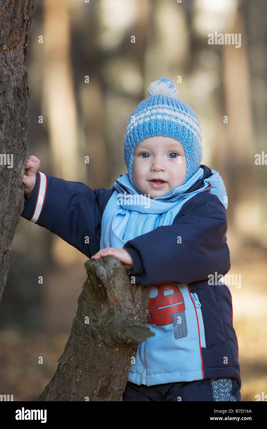 Einen kleinen Jungen auf einem Baumstumpf gelehnt Stockfoto