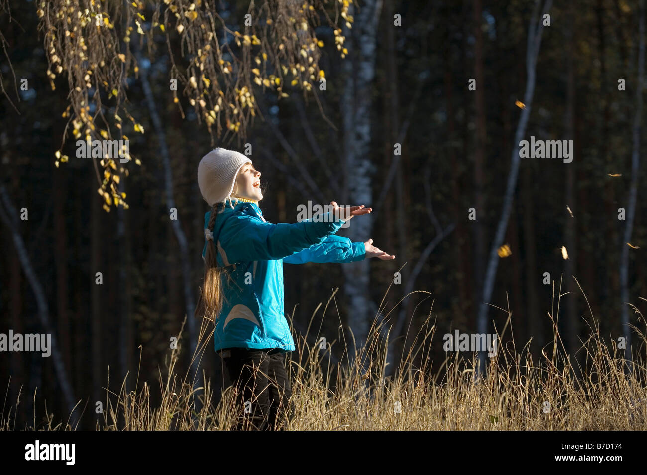 Ein junges Mädchen in einem Feld, die Blätter fangen Stockfoto