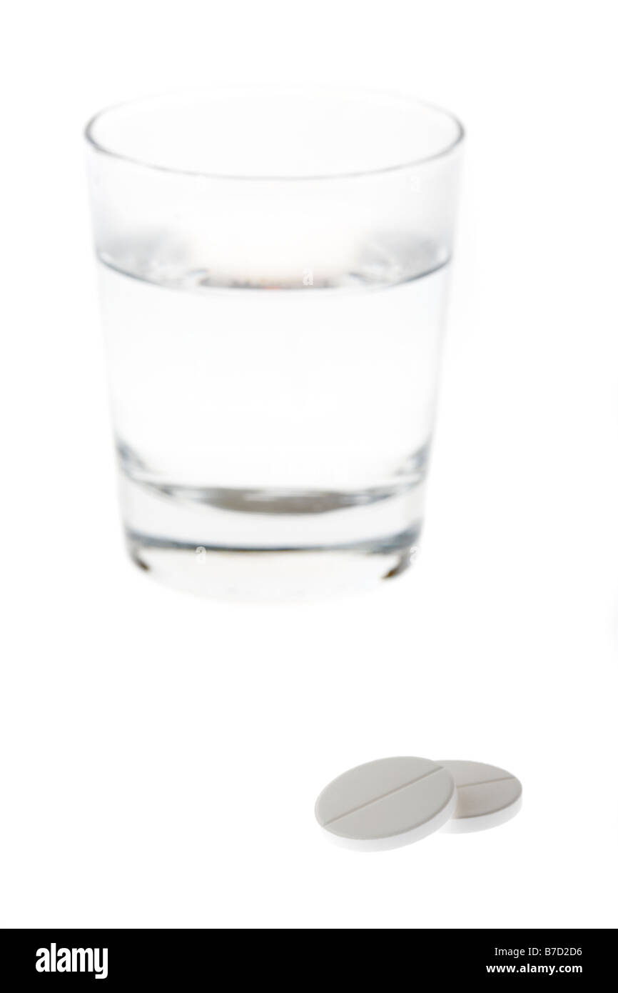 Glas halb leer mit Wasser, mit zwei großen lösliches Paracetamol Tabletten isoliert auf weißem Hintergrund voll Stockfoto