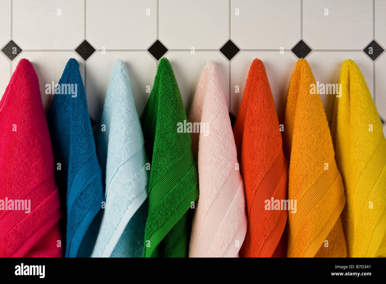 Multi farbige Handtücher hängen in einer Reihe an der Wand Stockfoto