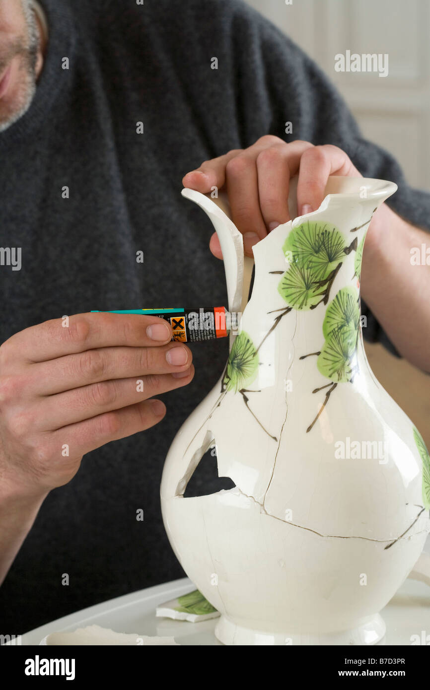Ein Mann, eine zerbrochene Vase reparieren Stockfotografie - Alamy