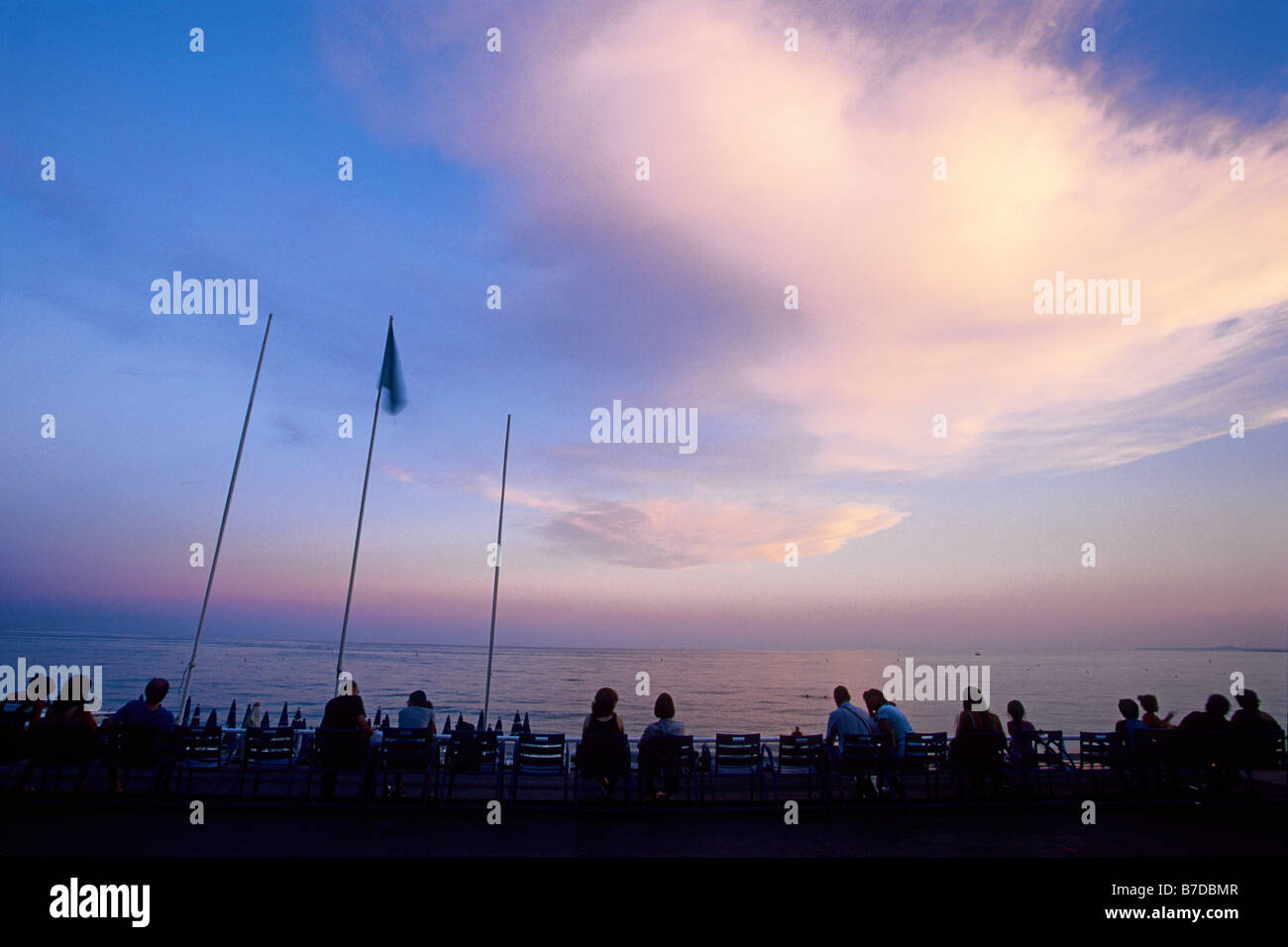 Menschen beobachten Sonnenuntergang an der Promenade des Anglais Stockfoto