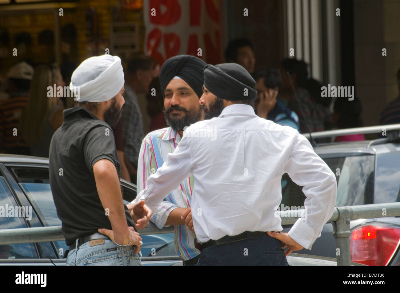 Drei indische Einwanderer Sikhs im Chat auf der Straße in Melbourne Australien Stockfoto
