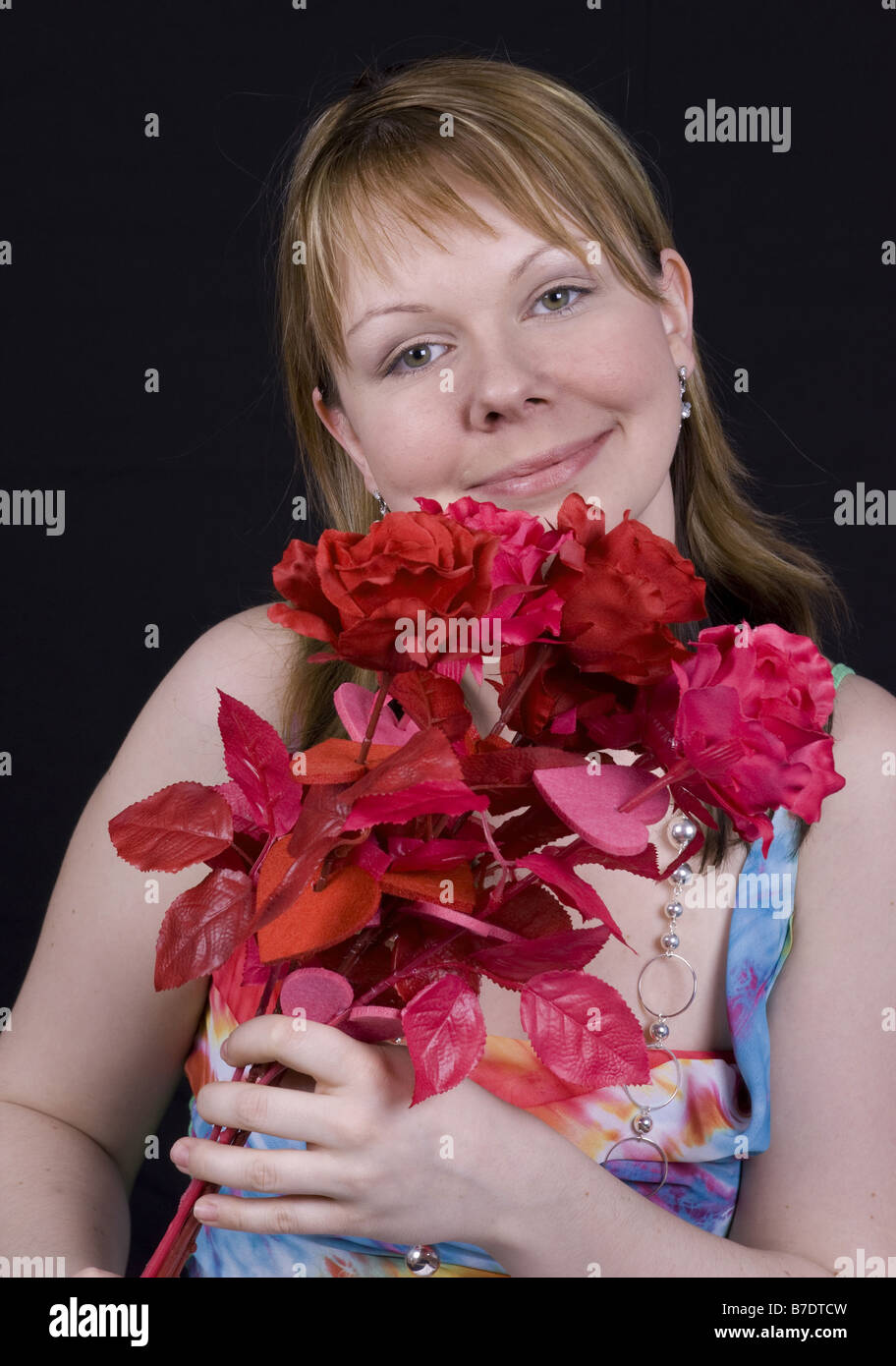 junge Frau mit künstlichen Rosenstrauss Stockfoto