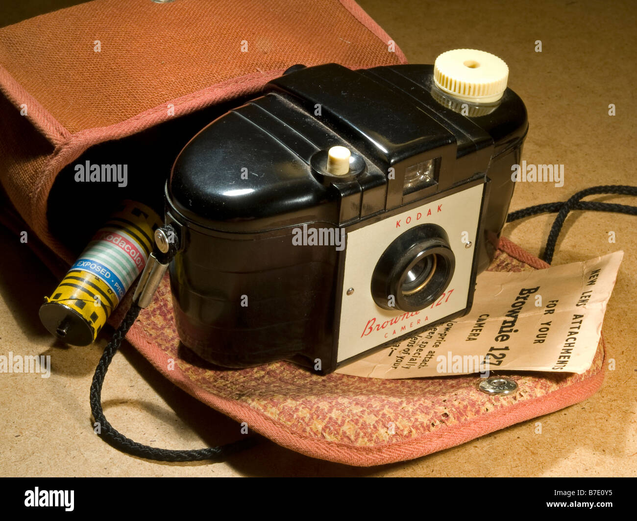 Stillleben mit Kodak Brownie 127 Kamera mit Gehäuse und eine Filmrolle Farbe Stockfoto