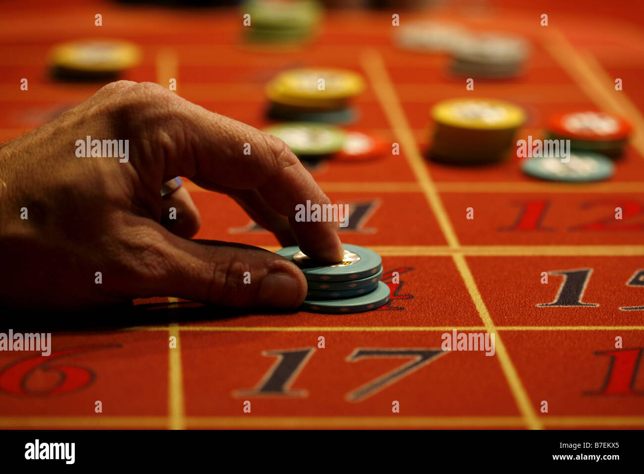 Ein Mann setzt eine Wette auf einem Roulette-Tisch Stockfoto