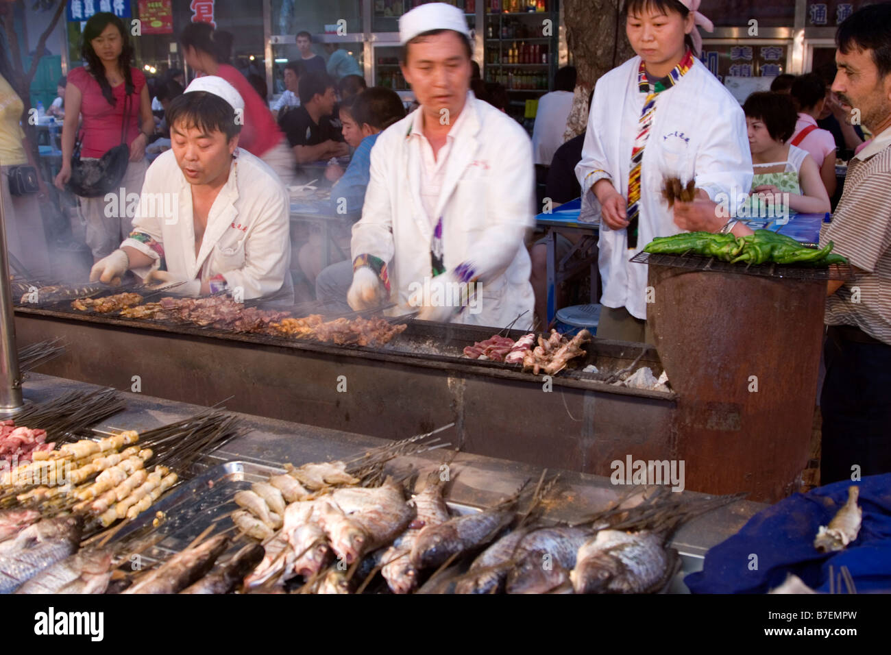 Spieße mit Fisch, Gemüse und Fleisch gegrillt auf Holzkohle bei Nacht-Food-Markt in Urumqi Xinjiang Chinas Hauptstadt Stockfoto