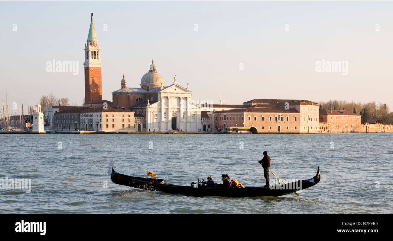Eine Gondel in Venedig übergibt die Insel San Giorgio Maggiore mit seiner Kirche mit dem gleichen Namen in den frühen Abendstunden Stockfoto