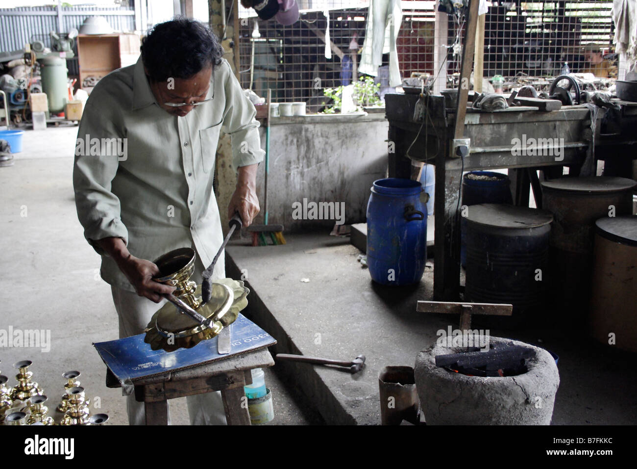 Ein Schmied arbeitet an Messinggeschirr in Terengganu, Malaysia. Stockfoto