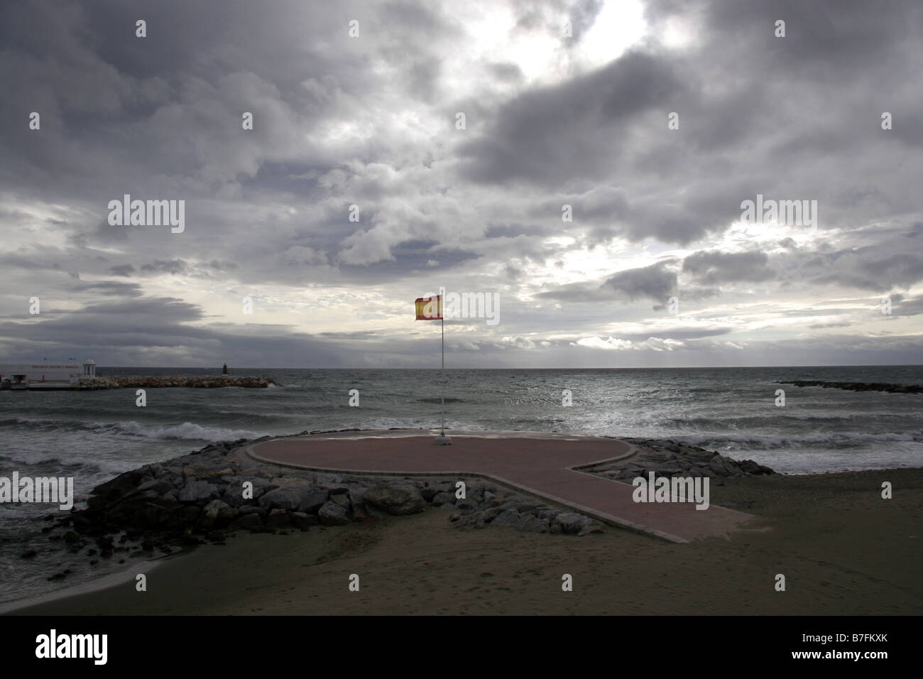 Gewitterwolken über der Spanisch Flagge an der Küste in Benalmadena Costa Del Sol Spanien Stockfoto