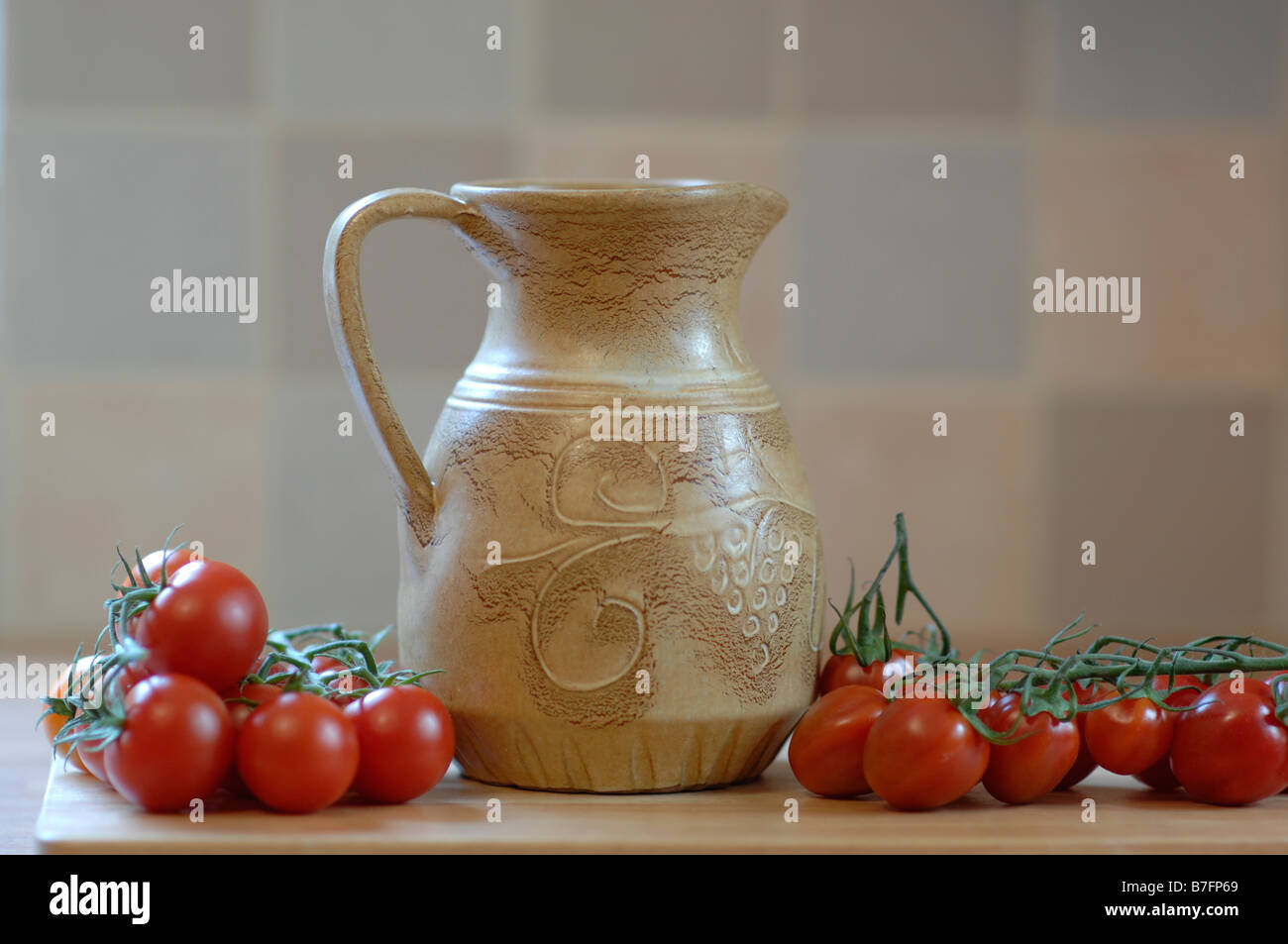 Krug und Tomaten am Rebstock Stockfoto