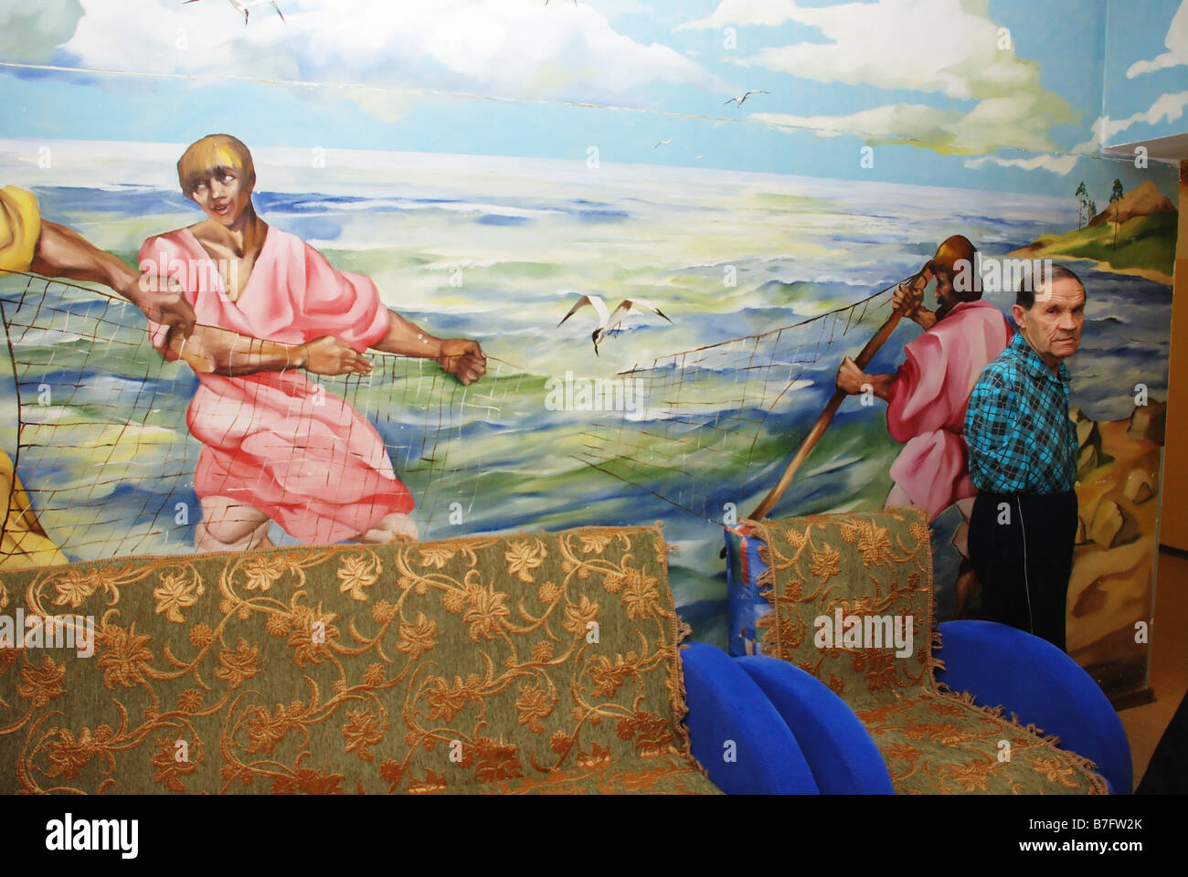 Einen alten einarmigen Mann in den Ruhestand nach Hause allein in der Nähe der bemalten Wand stehend Stockfoto