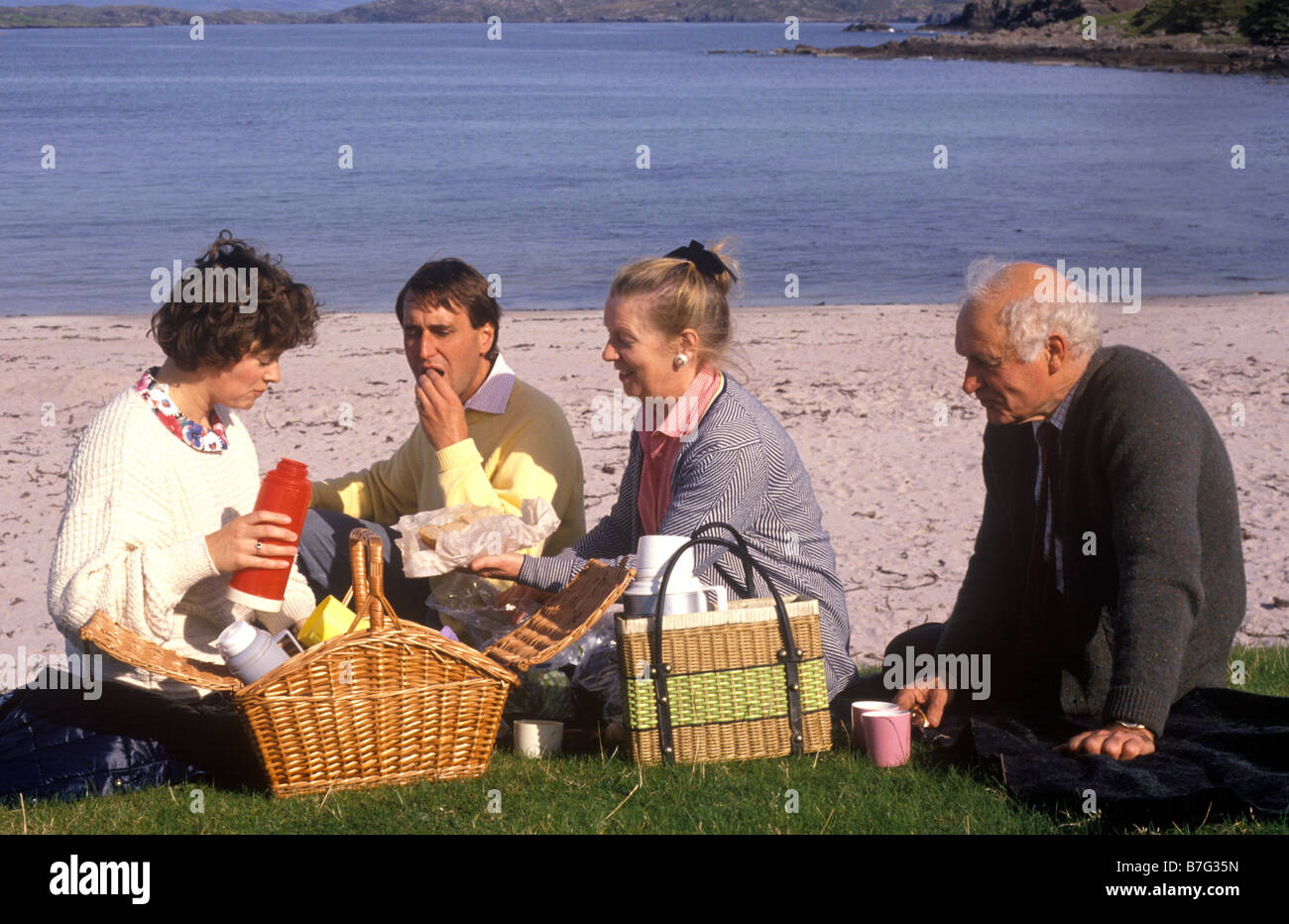 paar mit älteren Eltern mit einem Picknick an einem schottischen Strand Stockfoto