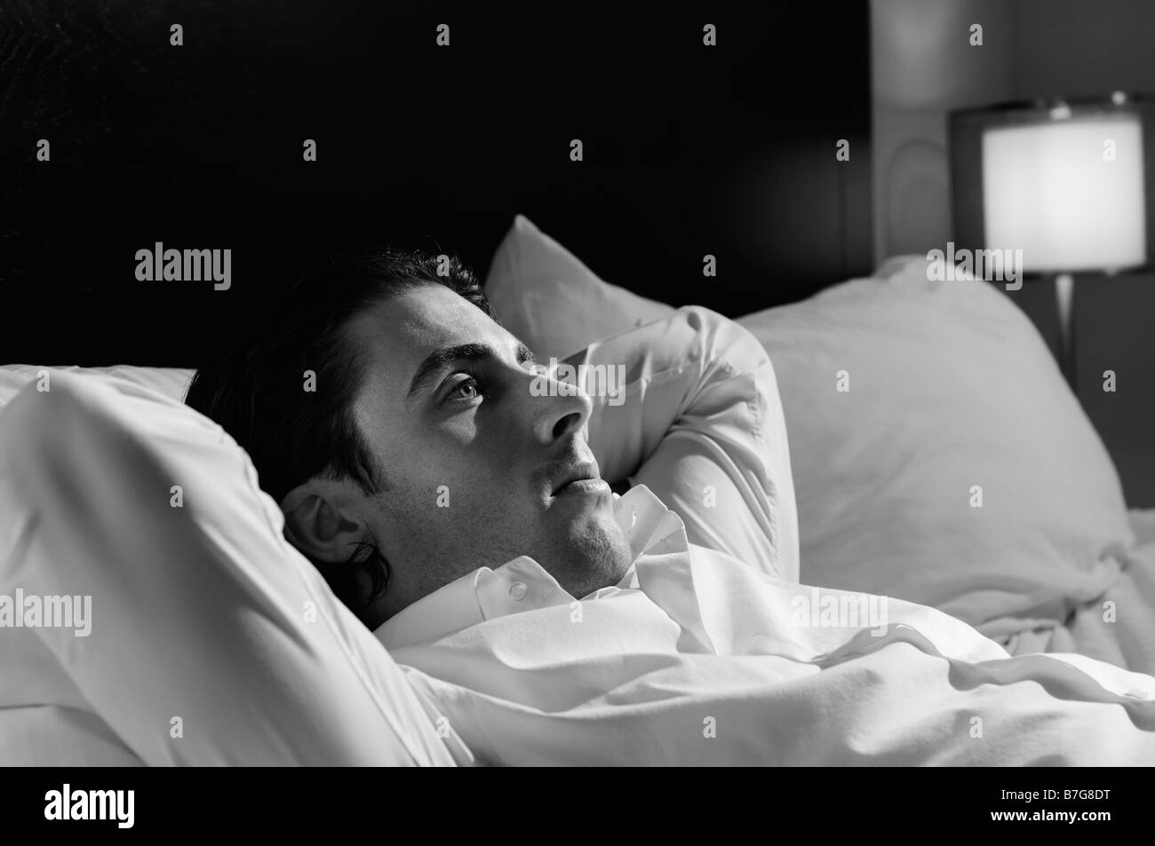 Junger Mann allein im Bett Stockfoto