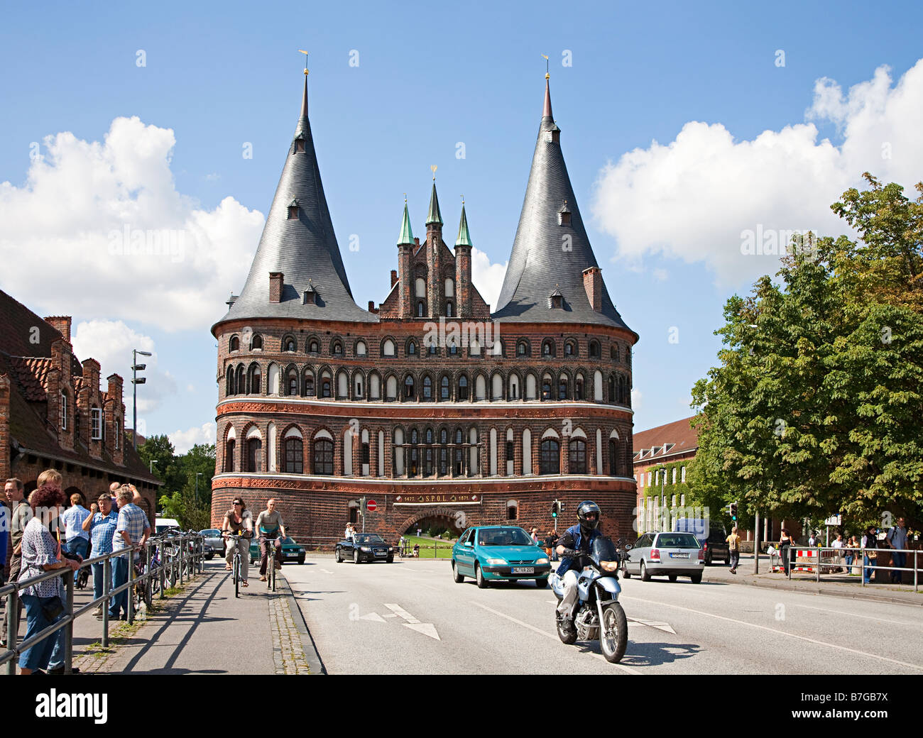 Verkehr beschäftigt und Radweg am Stadttor Holstentor Lübeck Deutschland Stockfoto