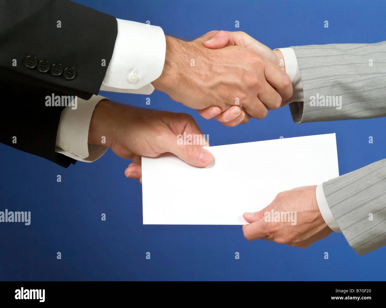 Zwei Menschen, Hände schütteln und den Austausch von einem weißen Umschlag mit verfügbaren textfreiraum zum Einfügen von text Stockfoto