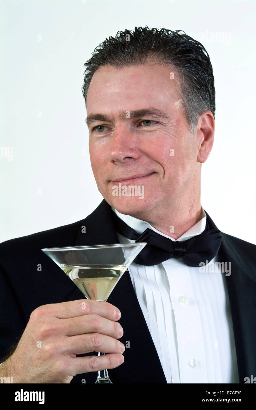 Ein Mann in formelle Kleidung mit einem liebevollen Ausdruck auf seinem Gesicht und einem Martini-Glas in der hand Stockfoto