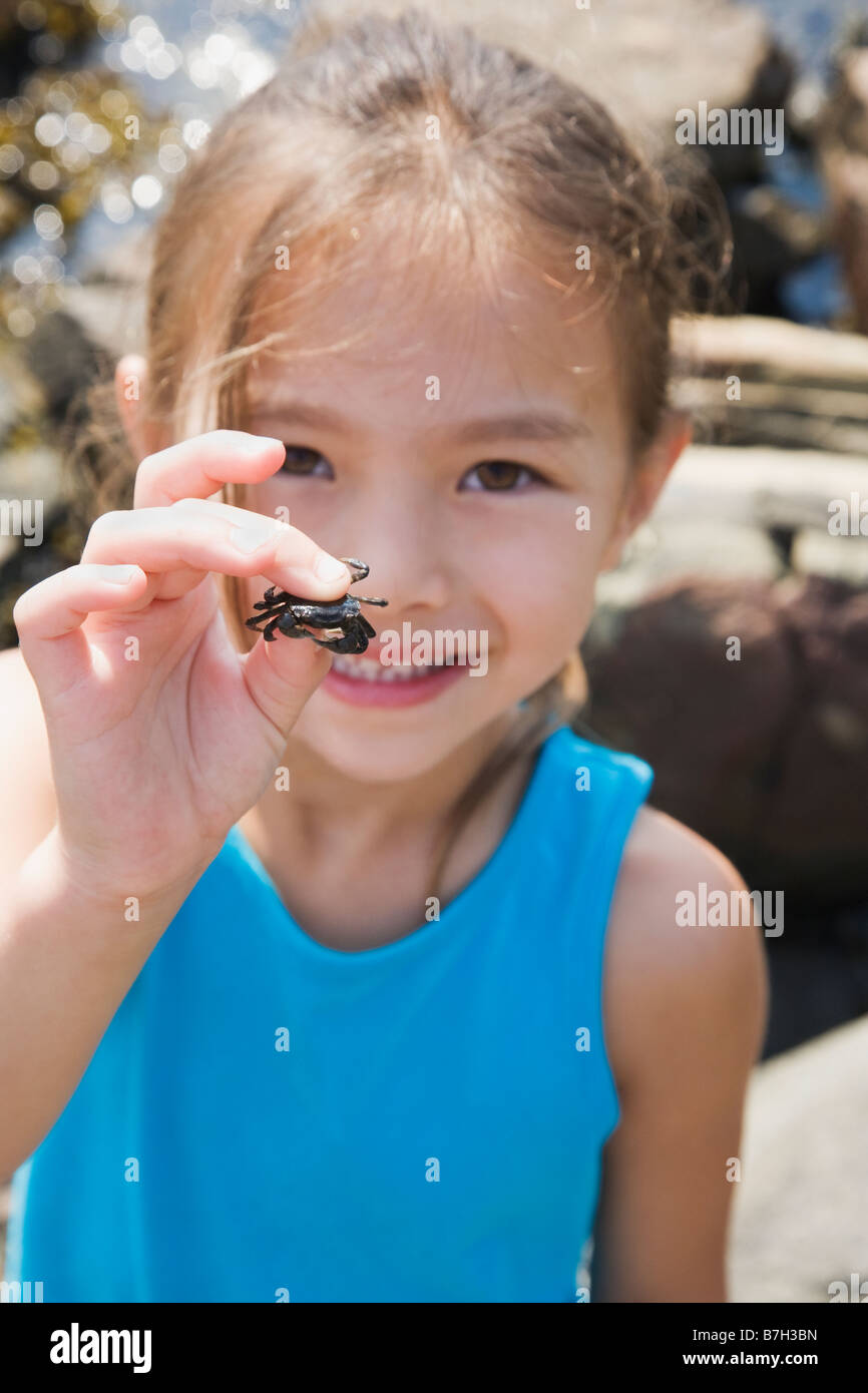 Asiatische Mädchen halten kleine Krabbe Stockfoto