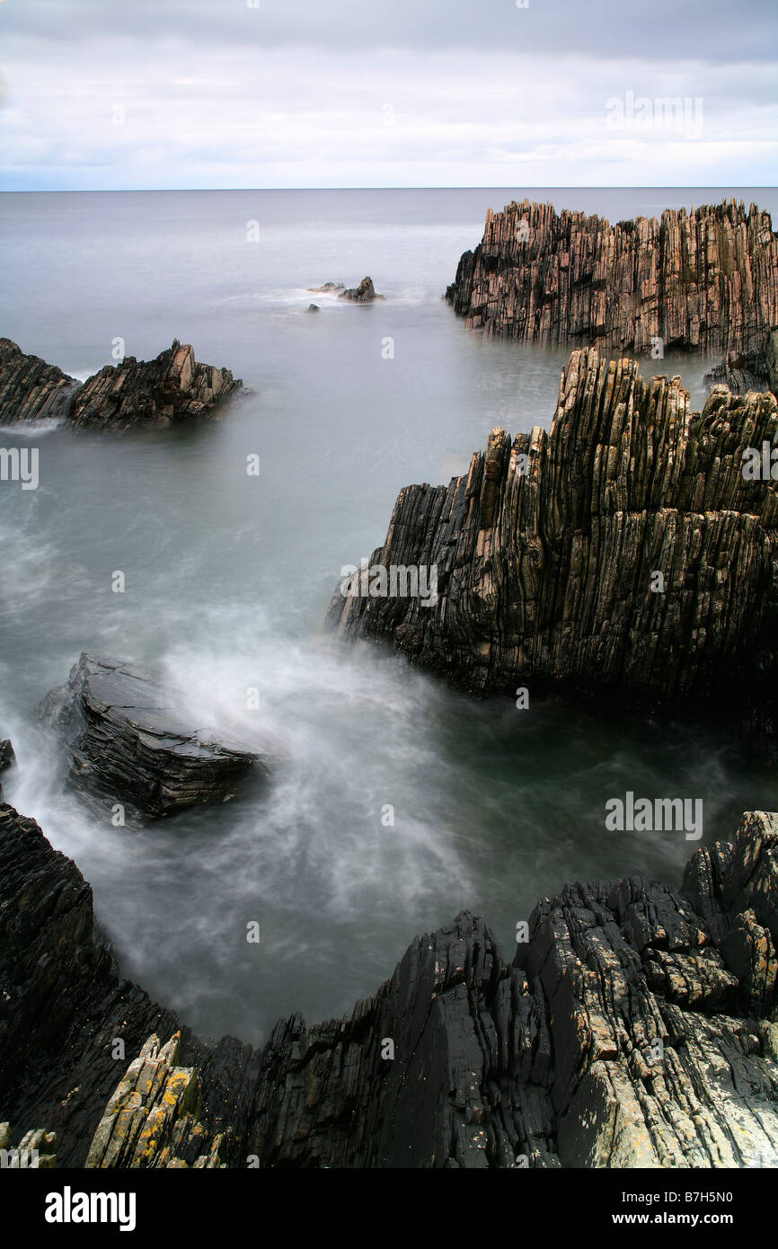 Felsen ragen aus dem Meer an der schottischen Küste getroffen Stockfoto