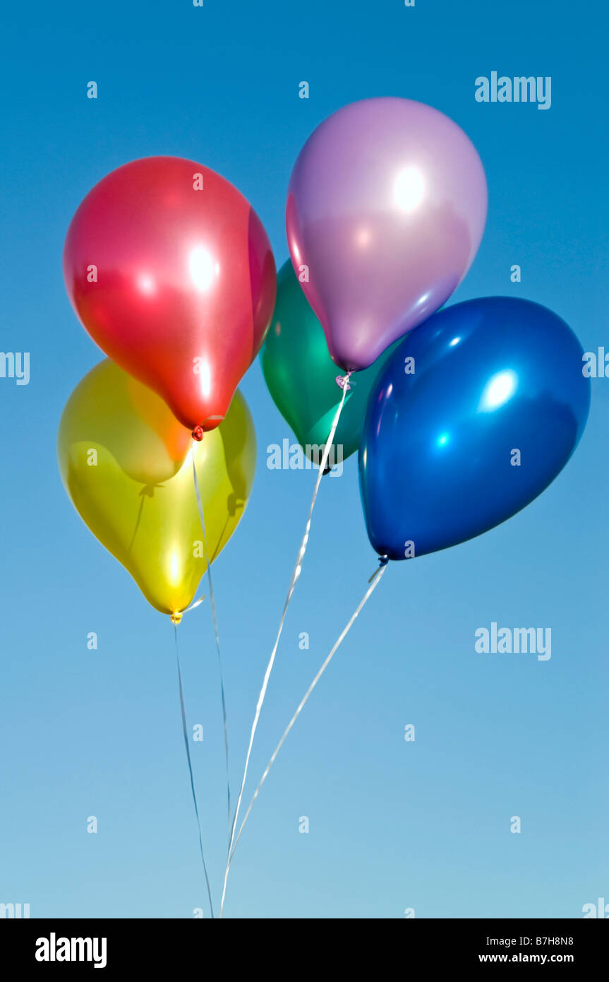 Vertikal nah füllte sich eine Reihe von bunten Helium Latexballons vor blauem Himmel Stockfoto