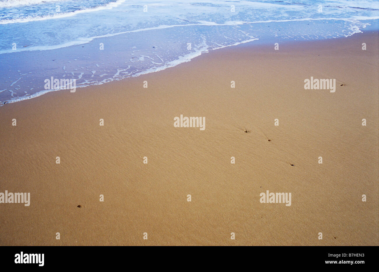 Detail der sanft plätschernden Wellen auf saubere menschenleeren Sandstrand Stockfoto