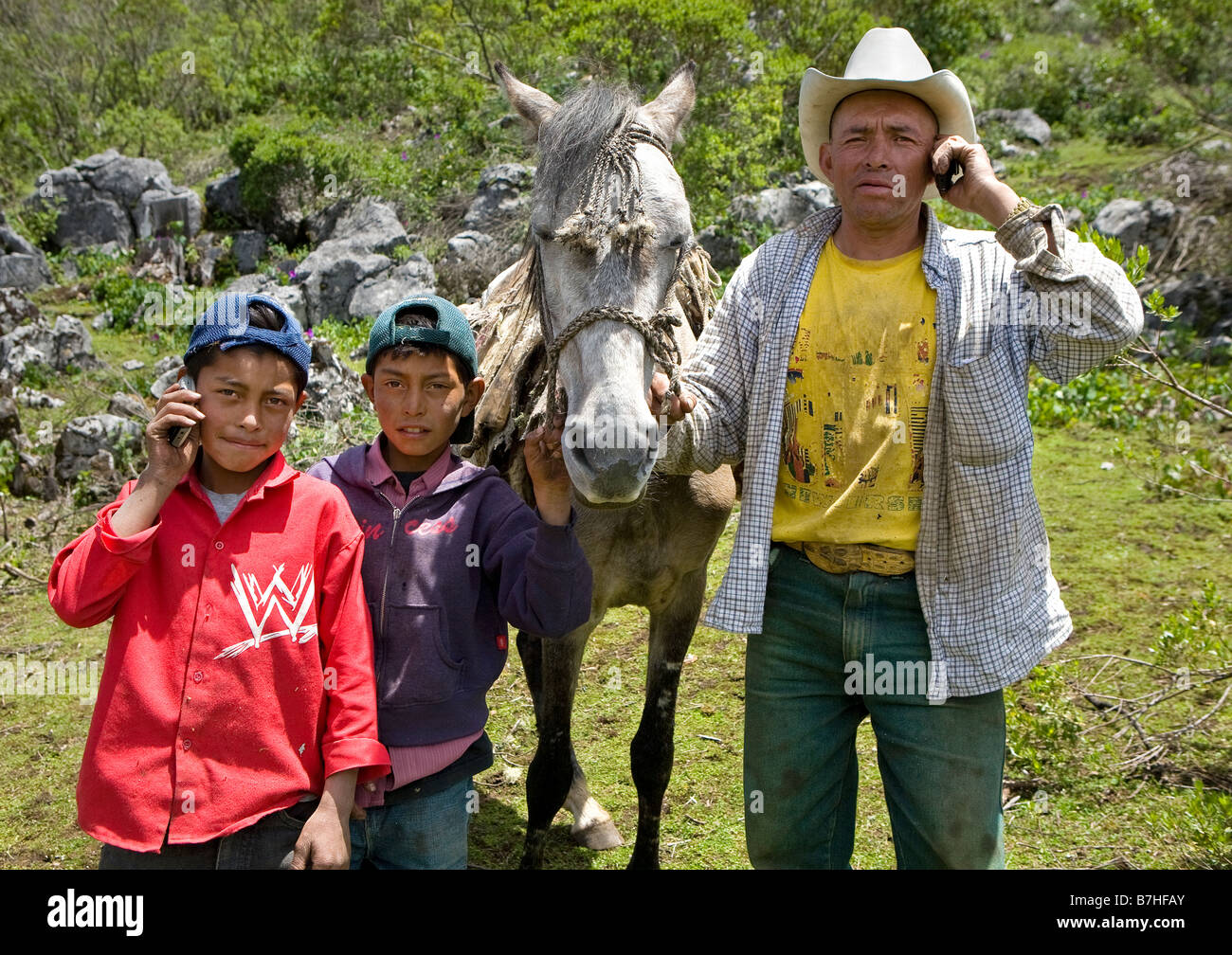 Vater und Söhne posiert mit Handys auf dem Lande in der Nähe von San Nicolas Western Highlands Guatemala Stockfoto
